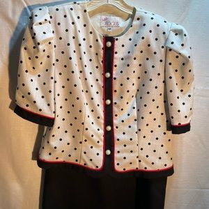 nice out fit with white jacket trimmed in black with black dots. Black skirt.